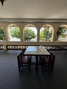 a table and chairs in a room with windows at Oakeland By Grovien in Ponnāni