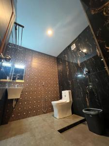 a bathroom with a toilet and a sink at Oakeland By Grovien in Ponnāni