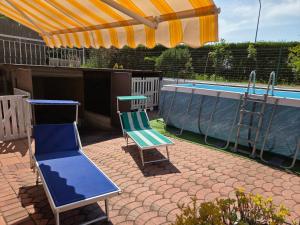 two chairs and a table next to a swimming pool at Casa PO LAZISE in Lazise