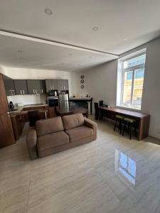 a living room with a couch and a kitchen at Valletta Waterfront Hideaway in Il-Furjana