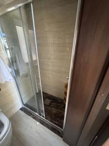 a shower with a glass door next to a toilet at Valletta Waterfront Hideaway in Il-Furjana