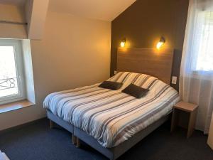 a bedroom with a large bed with two pillows on it at Logis Hôtel Restaurant Les Cévennes in Saint-Cirgues-en-Montagne