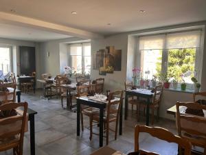 a dining room with tables and chairs and windows at Logis Hôtel Restaurant Les Cévennes in Saint-Cirgues-en-Montagne +55 photos