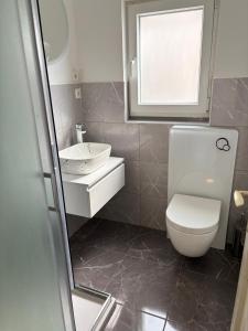 a bathroom with a toilet and a sink and a window at Donna Seahouse in Jadranovo +11 photos