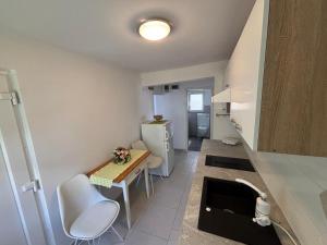 a small kitchen with a table and white chairs at Donna Seahouse in Jadranovo
