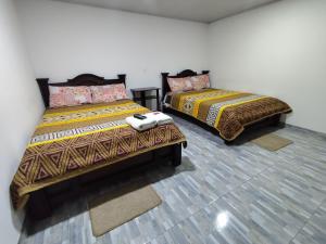 two beds sitting in a room with at Hotel La Terraza Raquireña in Ráquira +24 photos