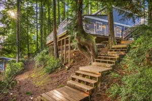 a house in the woods with stairs leading up to it at Lakefront retreat with view deck & private dock in Shelton
