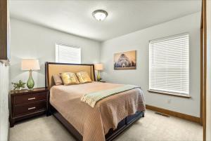 a bedroom with a large bed and two windows at Comfy & close to Lake Pend Oreille & Schweitzer in Dover