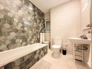 a bathroom with a tub and a toilet and a sink at St Julians - Spinola Space by DNA in St. Julianʼs +12 photos