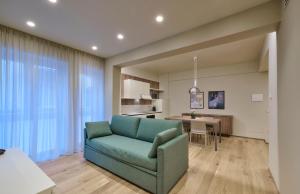 a living room with a blue couch and a table at Elegante appartamento - centro Lecco in Lecco