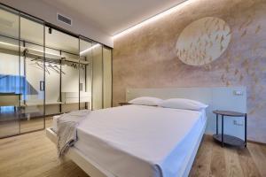 a bedroom with a large white bed and a table at Elegante appartamento - centro Lecco in Lecco