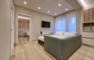 a bedroom with a bed and a couch and a television at Elegante appartamento - centro Lecco in Lecco