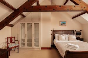 a bedroom with a bed and a chair at Puffin Cottage, Bamburgh in Bamburgh
