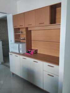 a kitchen with a counter top with a microwave at Apê Boa Vista in Vila Velha