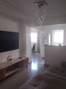 a living room with a bed and a television on a wall at Apê Boa Vista in Vila Velha