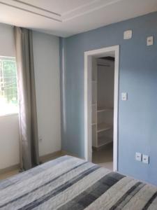 a bedroom with a bed with a blue wall at Apê Boa Vista in Vila Velha