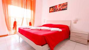 a red bed in a white room with a window at Residenza Pierre & Vacances Luni Mare in Luni