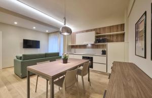 a living room with a table and a green couch at Elegante appartamento - centro Lecco in Lecco +12 photos