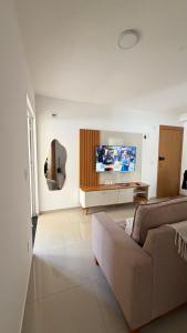 a living room with a couch and a flat screen tv at Apt 102 in Parnamirim