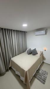 a bedroom with a bed and a window with curtains at Apt 102 in Parnamirim