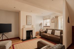 a living room with a couch and a fireplace at Puffin Cottage, Bamburgh in Bamburgh