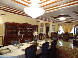una sala da pranzo con tavolo e lampadario pendente di The Executive Villa Inn & Suites a Davao