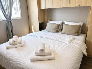 a bedroom with a large white bed with towels on it at Aurea Lux in Pakoštane +27 photos