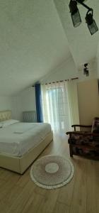 a bedroom with a bed and a rug on the floor at Sunrise Lindita in Pukë