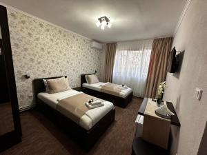 a hotel room with two beds and a table at Pensiunea La Cuscrii in Arad