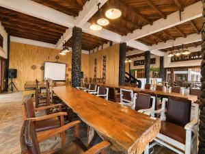 a restaurant with a large wooden table and chairs at Dulang Resort & Resto in Bongkar 2