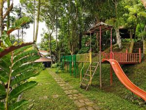a playground in a park with a slide at Dulang Resort & Resto in Bongkar 2