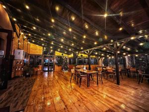 a restaurant with tables and chairs on a wooden floor at Pensiunea La Cuscrii in Arad
