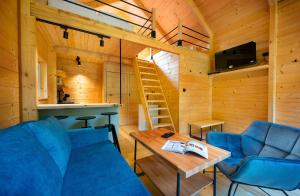 a living room with a blue couch and a table at Chata a Chalety Starý mlyn in Veľká Franková
