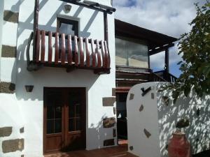 a white house with a wooden door and a balcony at Casa Rural "La Molina" in Máguez