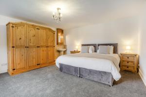 a bedroom with a large bed and wooden cabinets at 3 Bed in Kirriemuir oc-96450 in Kirriemuir
