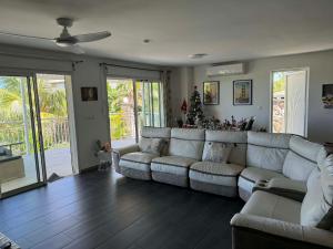 a living room with a couch and a christmas tree at Villa oasis des laves in Sainte-Rose