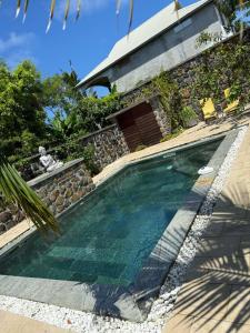 a swimming pool in front of a house at Villa oasis des laves in Sainte-Rose