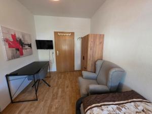 a room with a bed and a desk and a chair at FEWO Civrilli 1 Zeitz in Zeitz +2 photos
