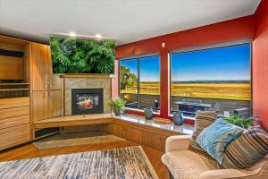 a living room with a fireplace and a large window at Spacious Gracious & Luxurious Retreat in Westport
