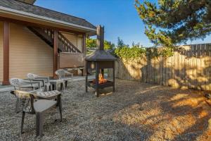 a backyard with a fire pit and chairs and a fence at Spacious Gracious & Luxurious Retreat in Westport