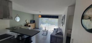 a kitchen and living room with a table and a couch at Maison familiale Montardon in Montardon