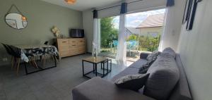 a living room with a couch and a large window at Maison familiale Montardon in Montardon
