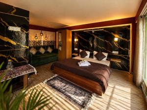a hotel room with a bed and a couch at Peakaboo Manali in Manāli