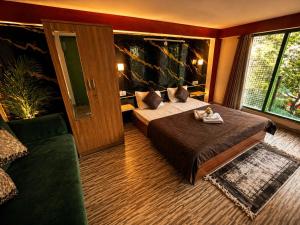 a hotel room with a bed and a couch at Peakaboo Manali in Manāli