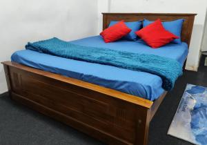 a bed with a blue blanket and red pillows at Sri VK Residency - Buget Friendly Colombo Hotel in Colombo