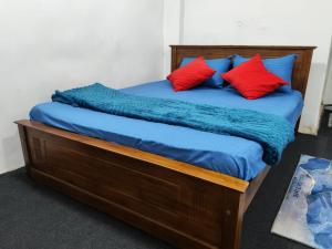 a bed with blue and red pillows on it at Sri VK Residency - Buget Friendly Colombo Hotel in Colombo +6 photos