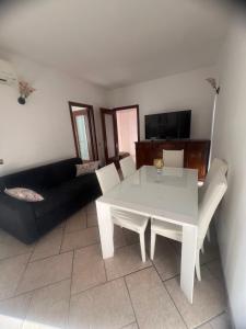 a living room with a white table and a black couch at Casa Castellano in Naples +4 photos