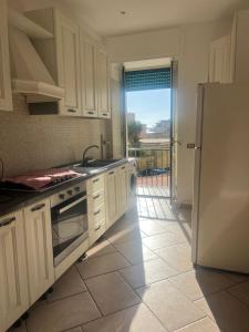a kitchen with white cabinets and a refrigerator at Casa Castellano in Naples