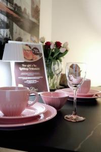 ein Tisch mit Tellern, Tassen und einem Weinglas in der Unterkunft Altmarktstudio1 in Cottbus