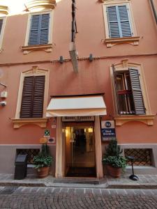 a pink building with a entrance to a store at Best Western Hotel Libertà in Modena